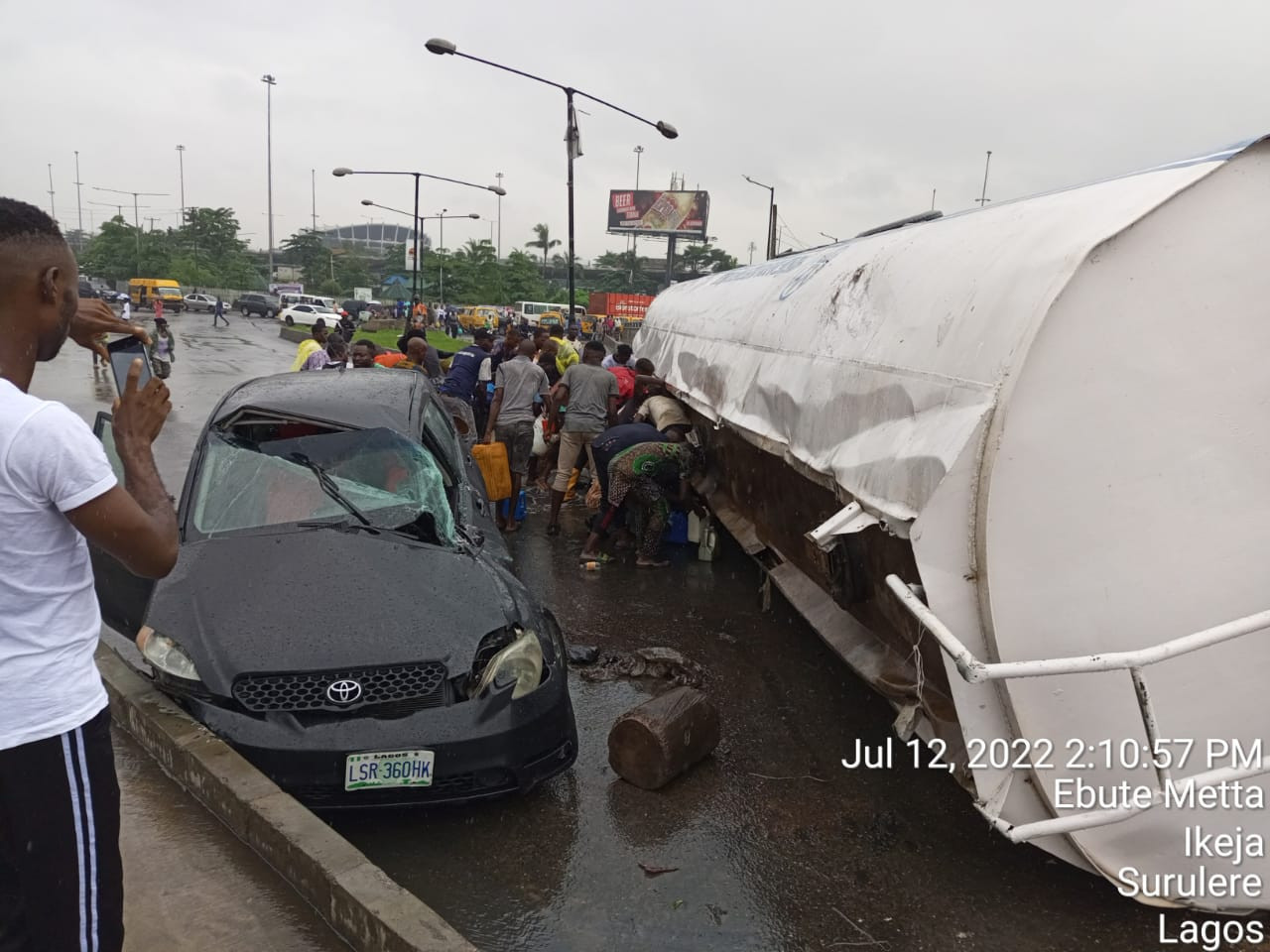 Loaded tanker falls at Costain, crushing car and spilling its content on the road (video)