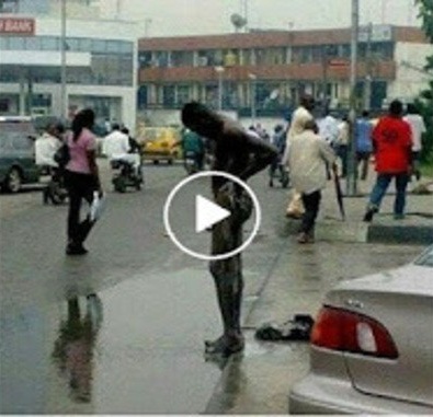 Unbelievable!!! Watch Video of A Yahoo Boy Bathing Along Street of Lagos Inn A Broad Day Light Just To Be Rich