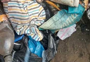 Shocking Discovery of a Fully Clothed Newborn Baby in a Refuse Dump at a Bus Stop in Lagos (Disturbing Images)