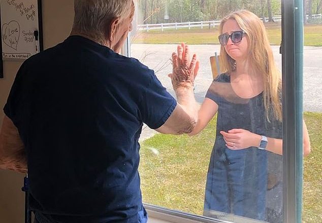 Coronavirus: Heartbreaking photos show woman showing off her engagement ring to her grandfather through the window of his nursing home because she can't go inside