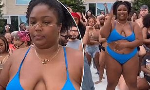 Lizzo shows some skin in a blue bikini while dancing with friends at a pool party