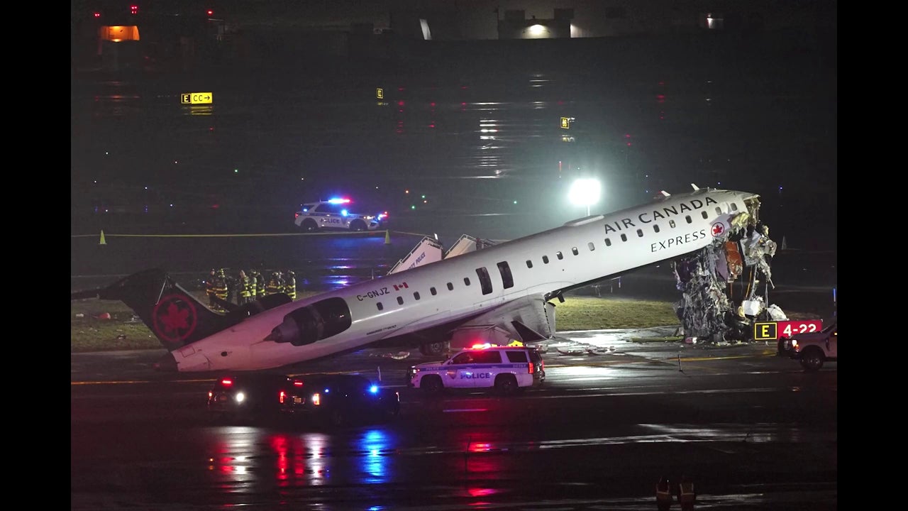 Two people die in collision between a plane and a fire truck at LaGuardia Airport in New York